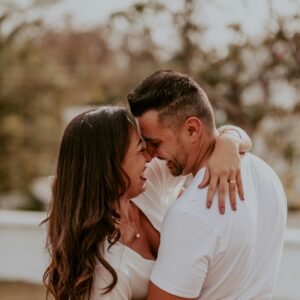A joyful couple embracing outdoors, capturing intimate and happy moments together in summer.