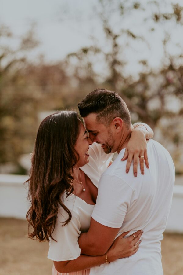 A joyful couple embracing outdoors, capturing intimate and happy moments together in summer.