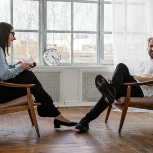Counselor and client in a positive therapy session in a well-lit room.
