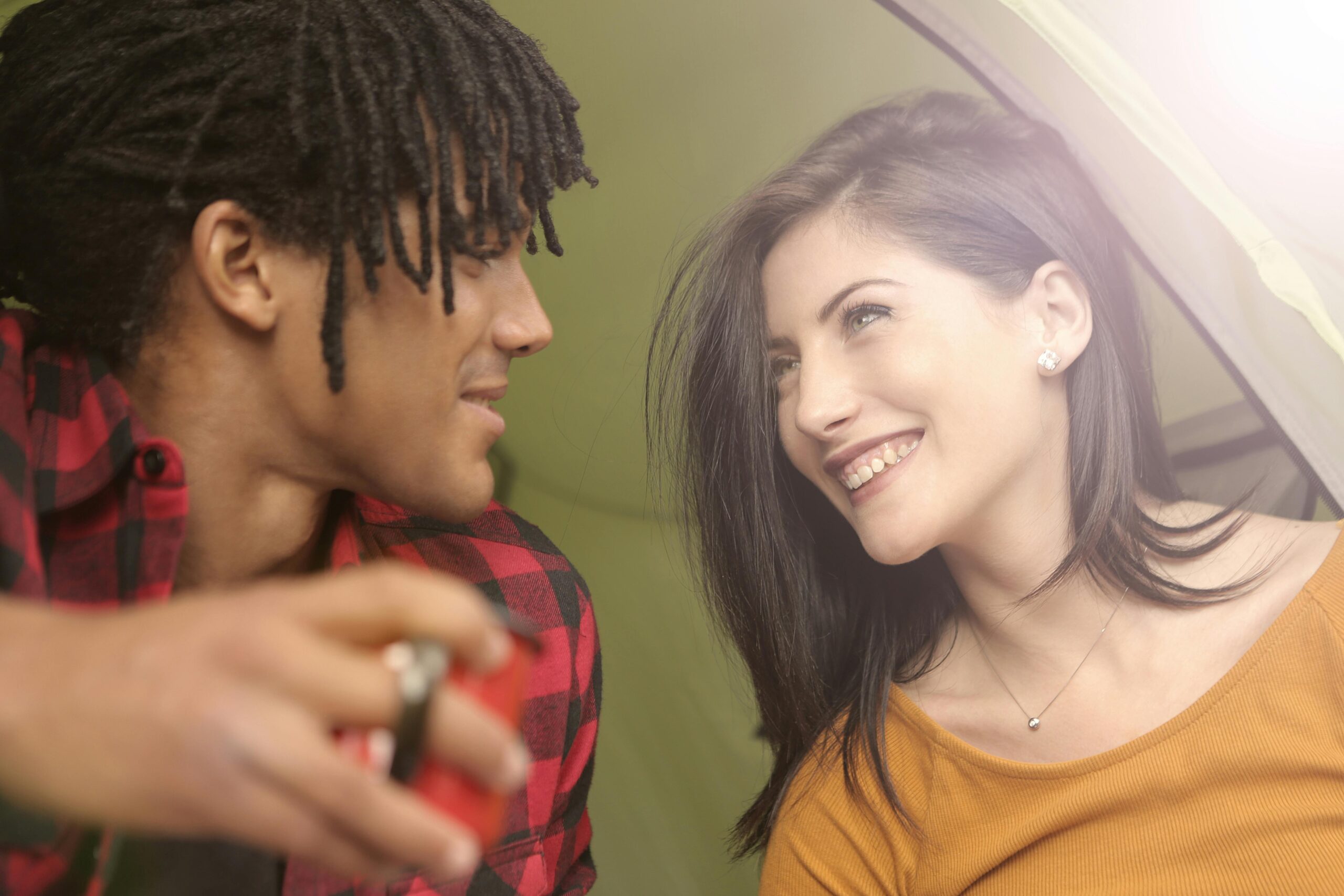A cheerful couple bonding and enjoying their camping experience, capturing a joyful moment indoors.
