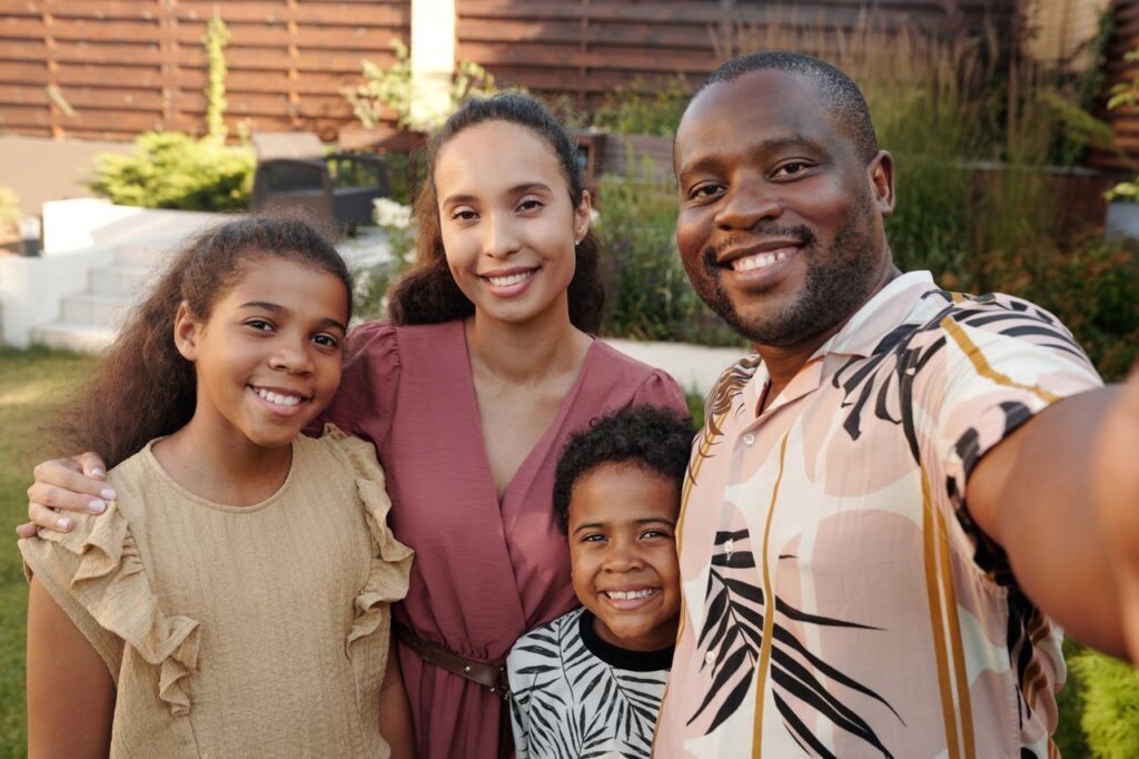 Smiling multicultural family enjoying time together outdoors in their garden.