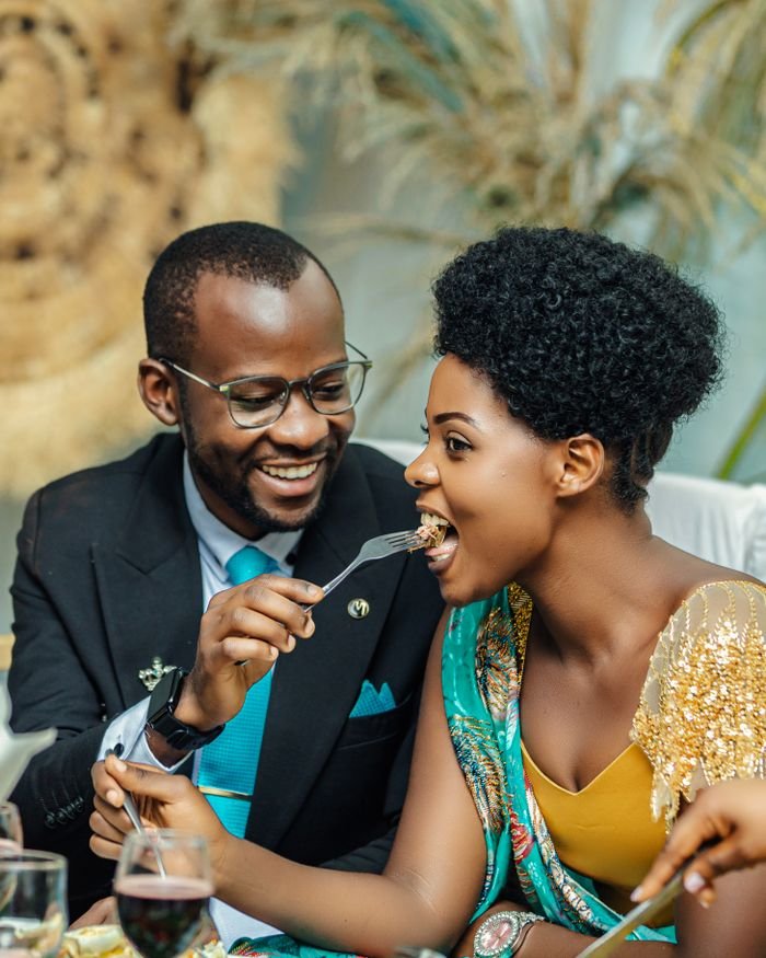 Joyful couple enjoying a meal together at a celebration, highlighting love and connection.
