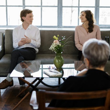 Couple engaged in a therapy session with a counselor in a loft setting.